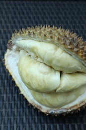 Photo of Fresh ripe durian on wicker table, above view