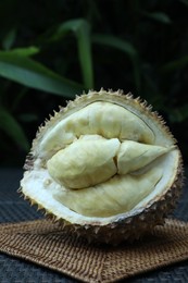 Photo of Fresh ripe durian on wicker table outdoors
