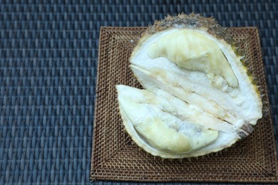 Photo of Fresh ripe durian on wicker table, above view. Space for text
