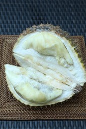 Photo of Fresh ripe durian on wicker table, above view