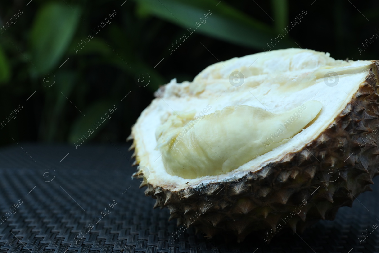 Fresh ripe durian on wicker table outdoors, closeup. Space for text Photo of Fresh ripe durian on wicker table outdoors, closeup. Space for text
