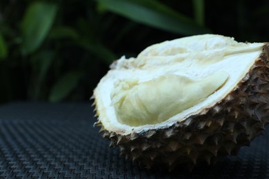 Photo of Fresh ripe durian on wicker table outdoors, closeup. Space for text