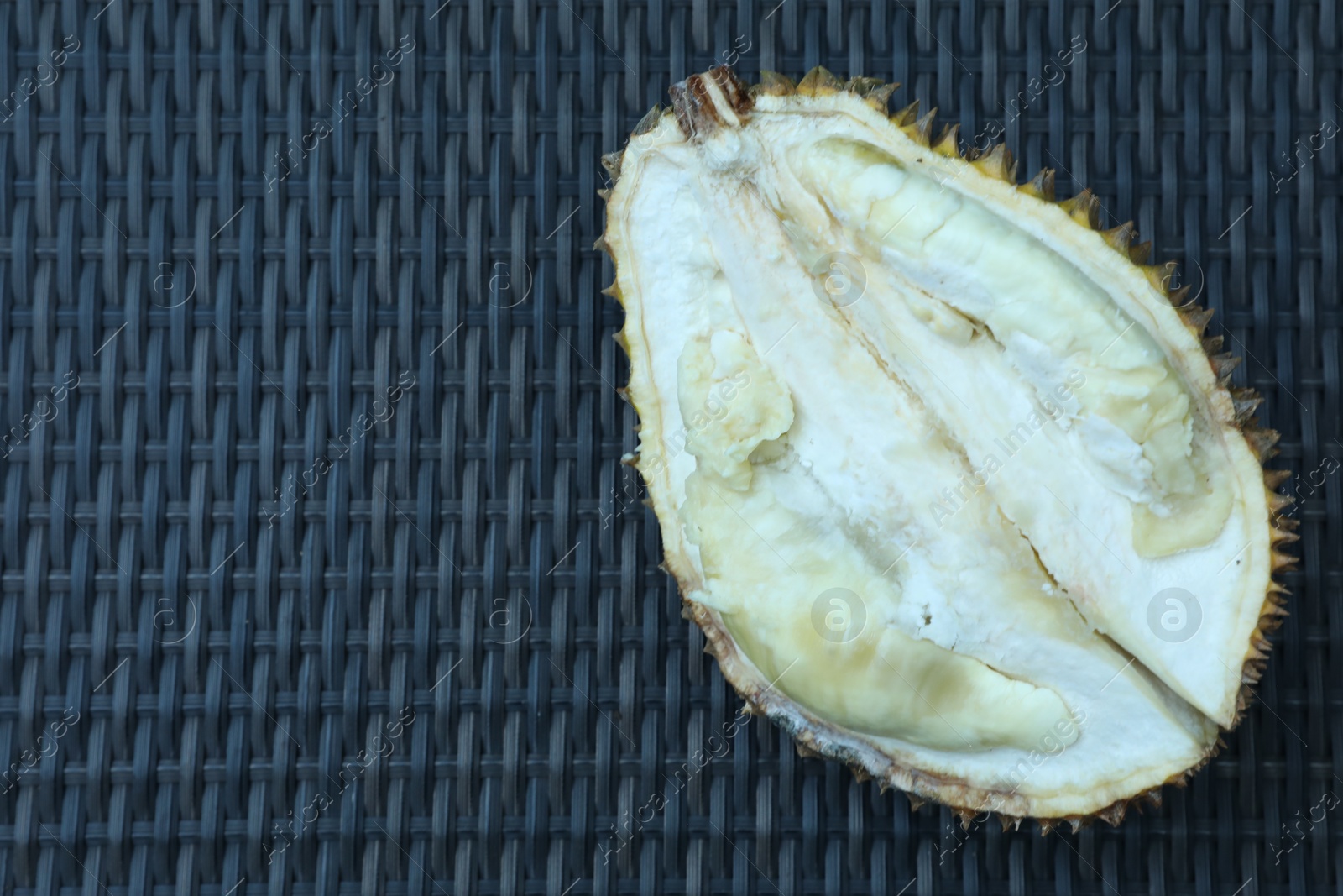 Fresh ripe durian on wicker table, top view. Space for text Photo of Fresh ripe durian on wicker table, top view. Space for text