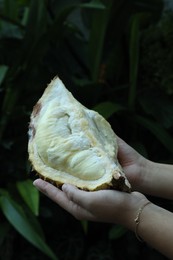 Photo of Woman with fresh ripe durian outdoors, closeup