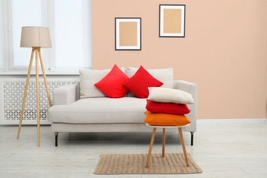 Image of Stylish living room with comfortable sofa and pink beige wall. Interior design