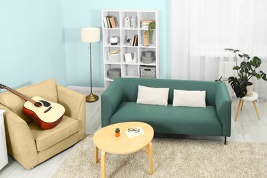 Image of Stylish living room with comfortable sofa and light blue wall. Interior design