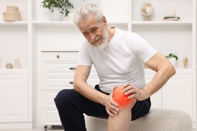 Image of Senior man suffering from pain in knee at home