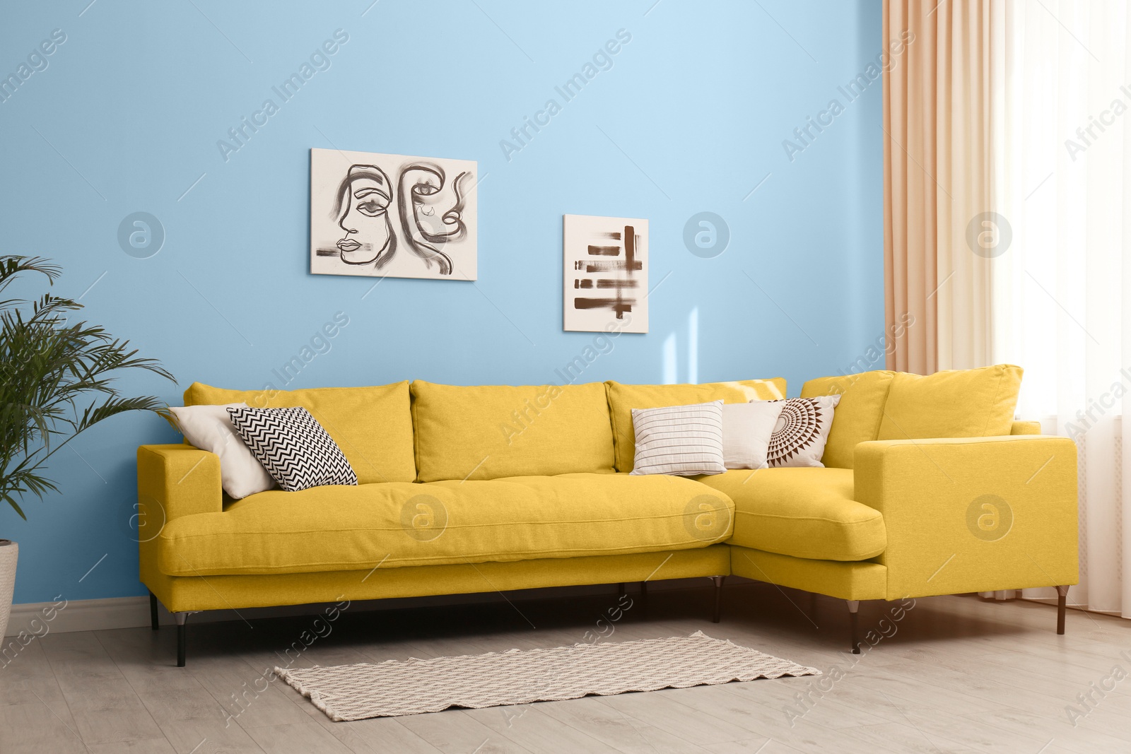 Stylish living room with yellow comfortable sofa and light blue wall. Interior design Image of Stylish living room with yellow comfortable sofa and light blue wall. Interior design