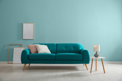 Image of Stylish living room with comfortable sofa and light blue wall. Interior design