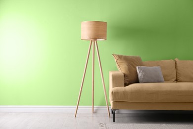Image of Stylish living room with comfortable sofa and light green wall. Interior design