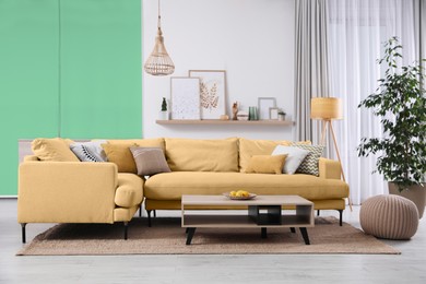 Image of Stylish living room with comfortable sofa and color wall. Interior design