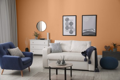 Image of Stylish living room with comfortable sofa and orange wall. Interior design