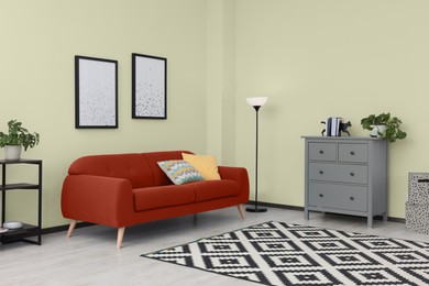 Image of Stylish living room with comfortable red sofa and beige wall. Interior design
