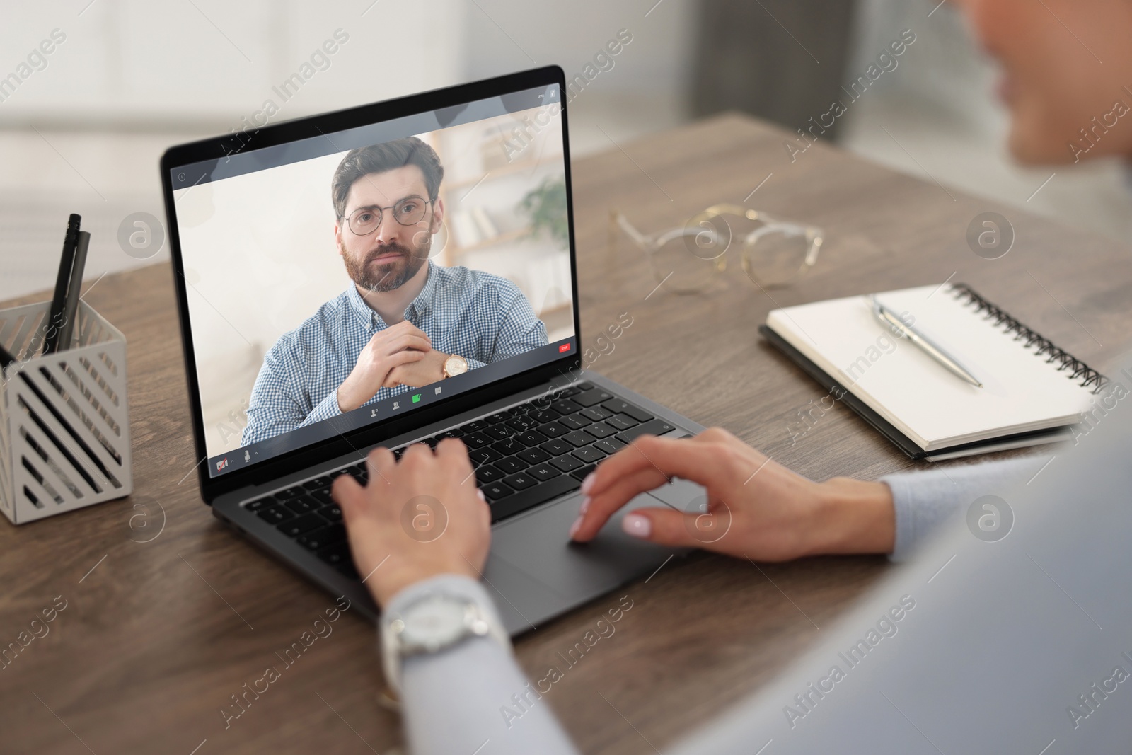 Online psychologist. Woman receiving counselling via video call on laptop at table, closeup Image of Online psychologist. Woman receiving counselling via video call on laptop at table, closeup