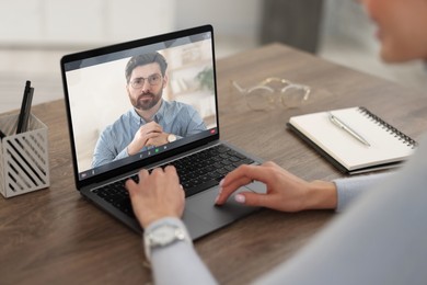 Image of Online psychologist. Woman receiving counselling via video call on laptop at table, closeup
