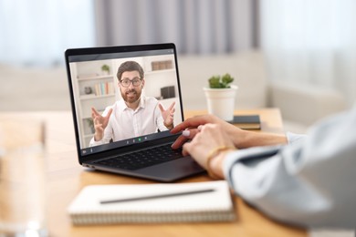 Image of Online psychologist. Woman receiving counselling via video call on laptop at table, closeup
