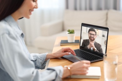 Image of Online psychologist. Woman receiving counselling via video call on laptop at table, closeup