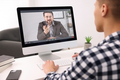 Image of Man having video chat with psychologist via computer at home. Online counselling