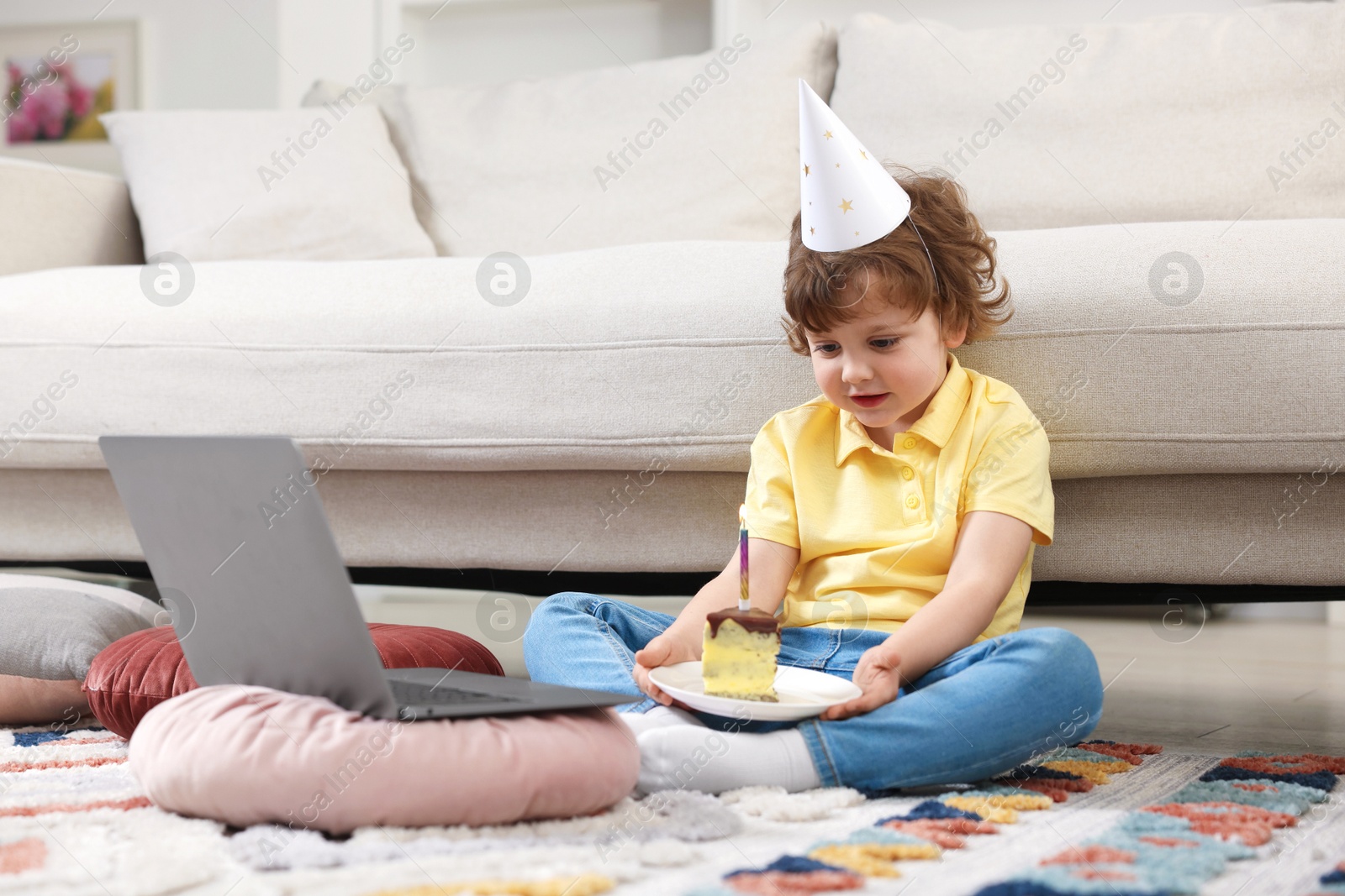 Birthday celebration. Little boy with piece of cake having video call via laptop at home Photo of Birthday celebration. Little boy with piece of cake having video call via laptop at home