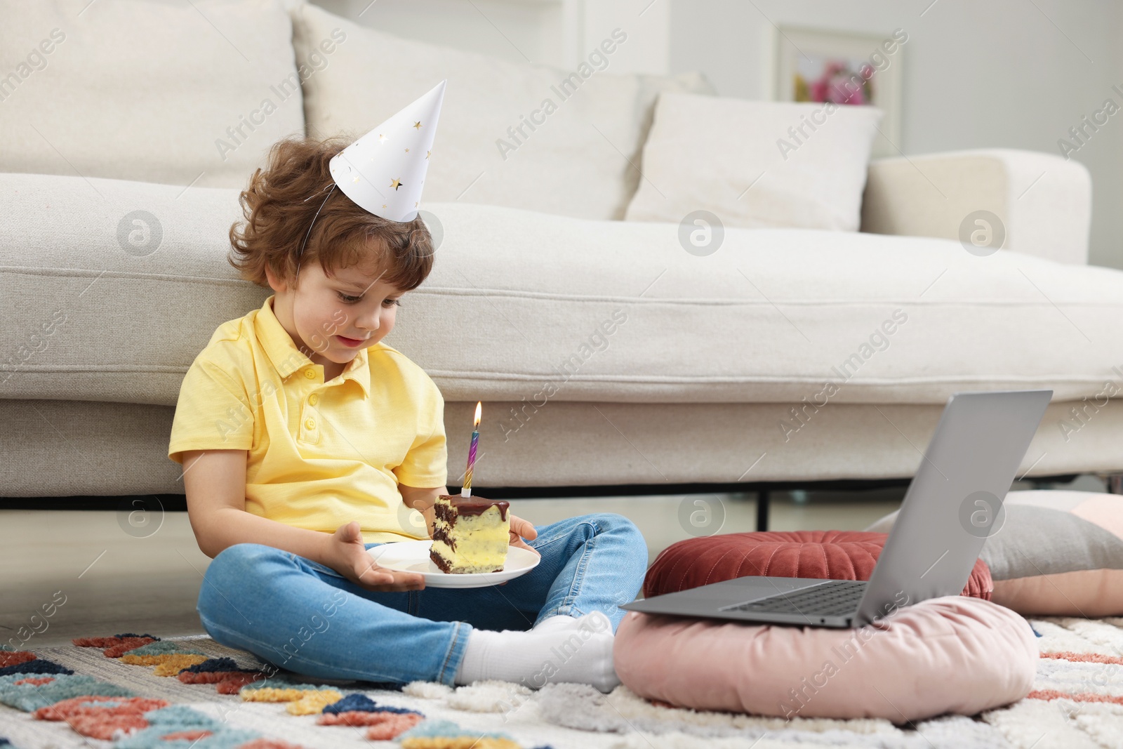 Birthday celebration. Little boy with piece of cake having video call via laptop at home Photo of Birthday celebration. Little boy with piece of cake having video call via laptop at home