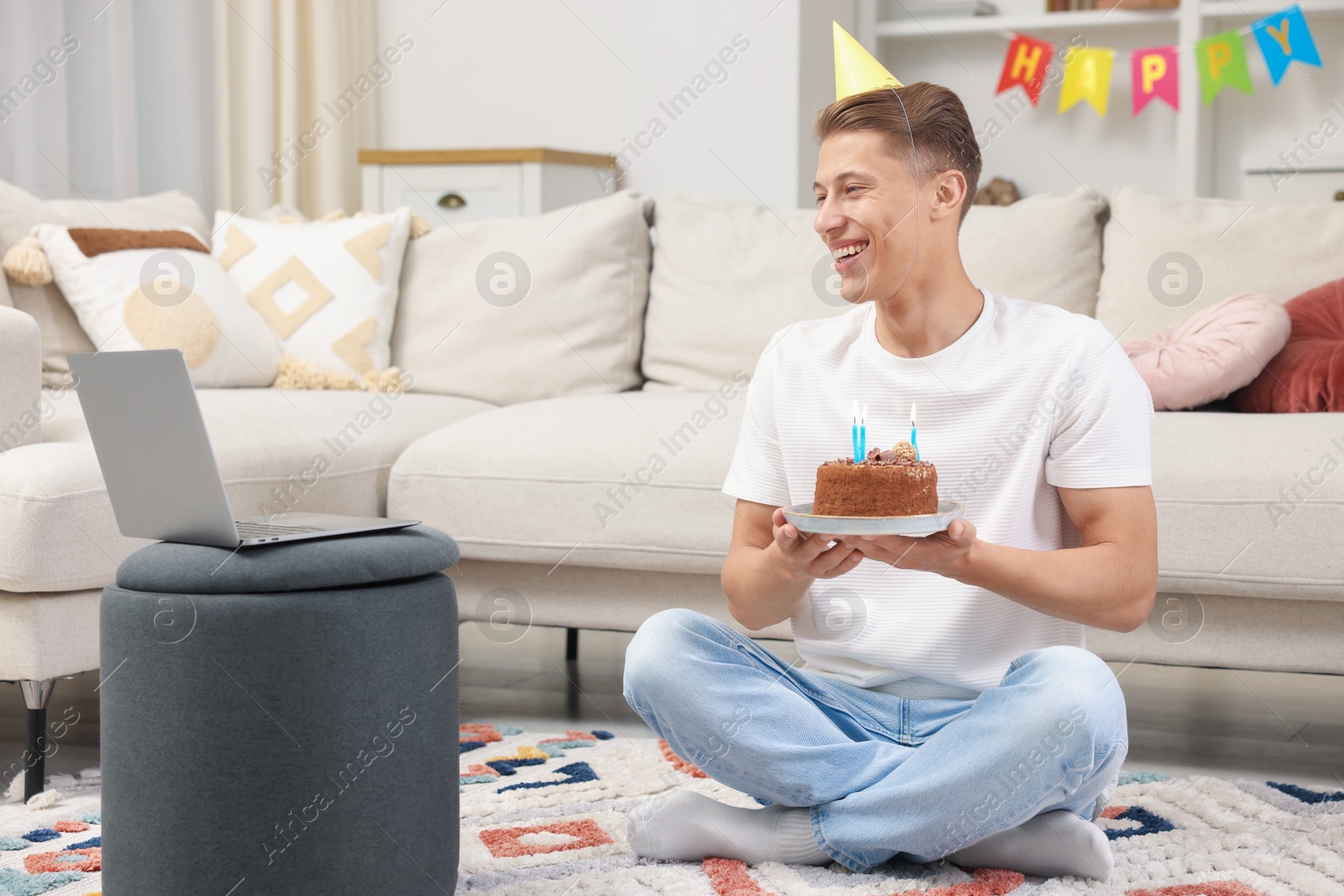 Man with cake celebrating his birthday and having video call via laptop at home Photo of Man with cake celebrating his birthday and having video call via laptop at home