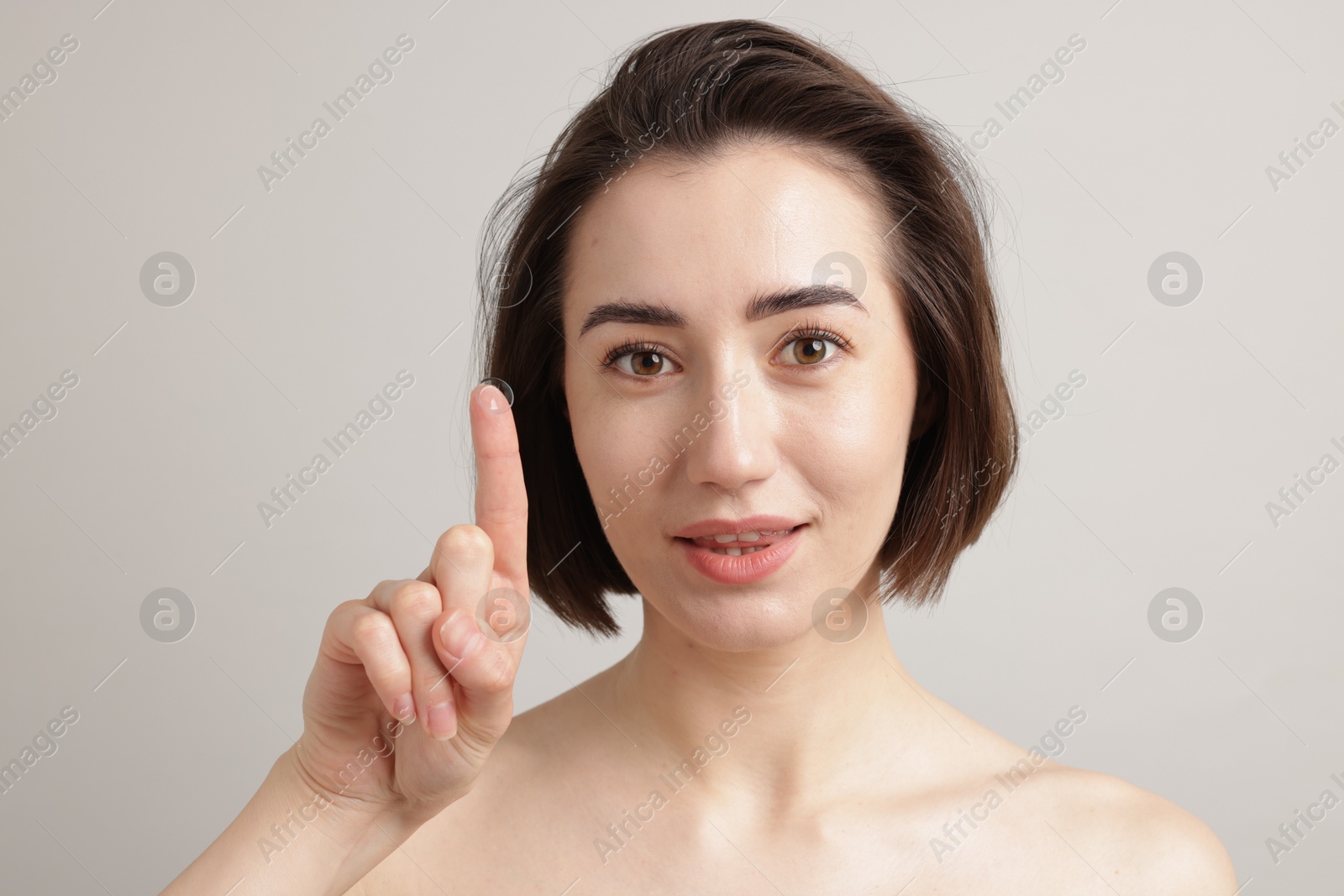 Photo of Woman with contact lens on light background