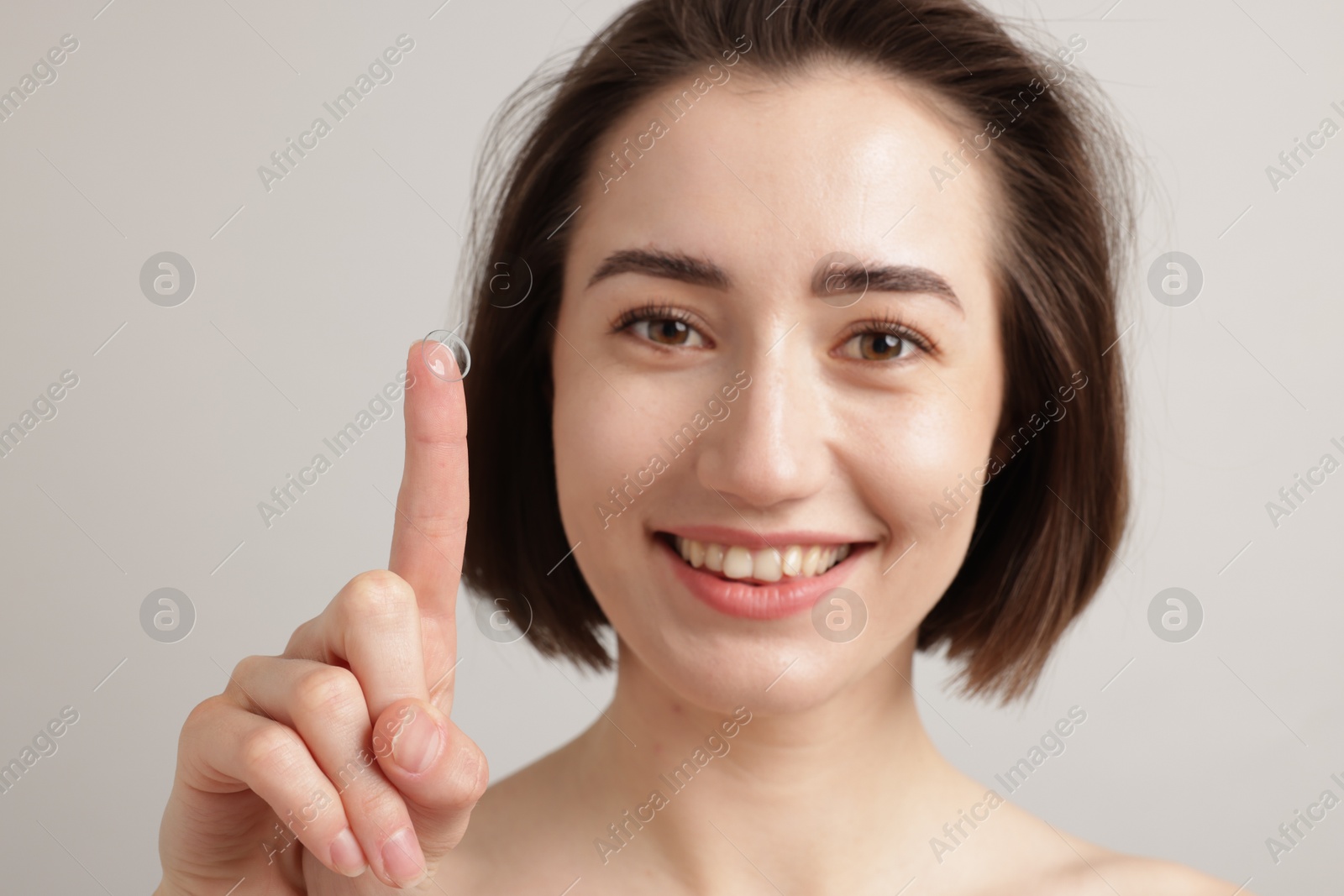 Woman with contact lens on light background Photo of Woman with contact lens on light background