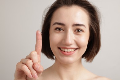 Photo of Woman with contact lens on light background