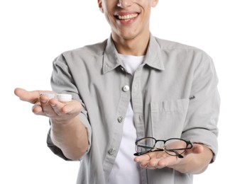 Photo of Man choosing between glasses and contact lenses on white background, closeup