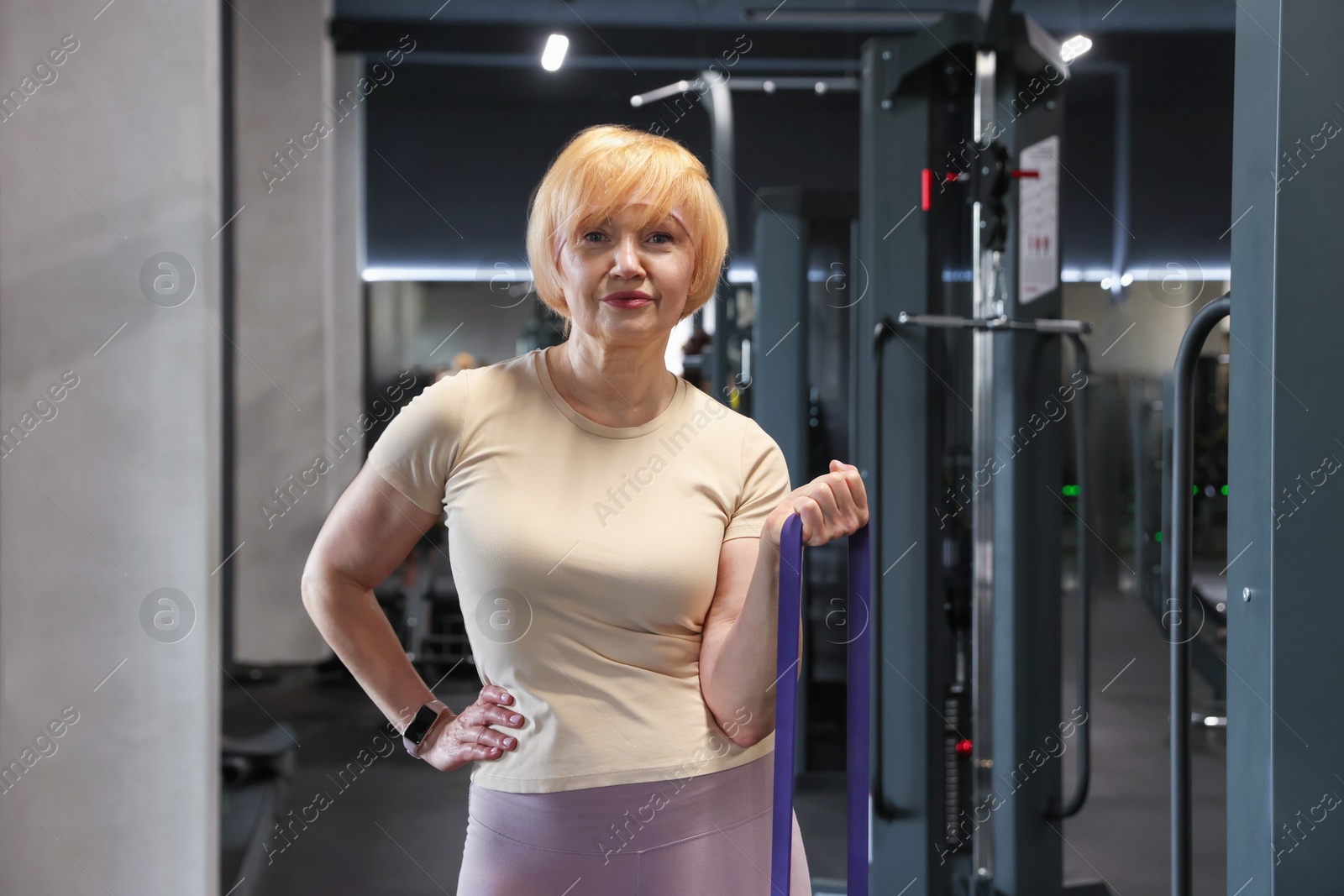 Senior woman doing exercise with fitness elastic band in gym Photo of Senior woman doing exercise with fitness elastic band in gym