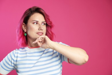 Photo of Beautiful woman with bright dyed hair on pink background