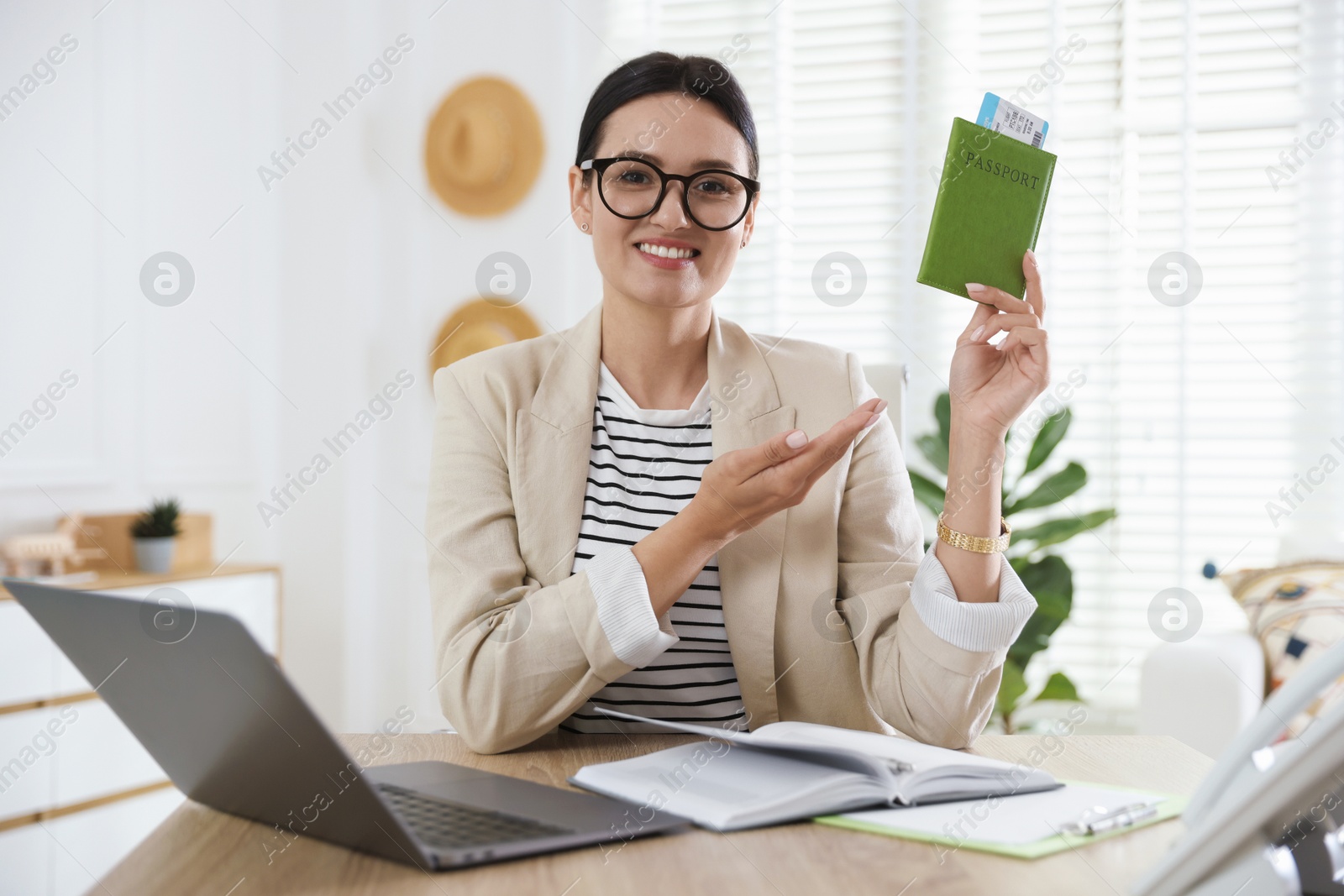 Travel agent with passport and ticket at wooden table in office Photo of Travel agent with passport and ticket at wooden table in office