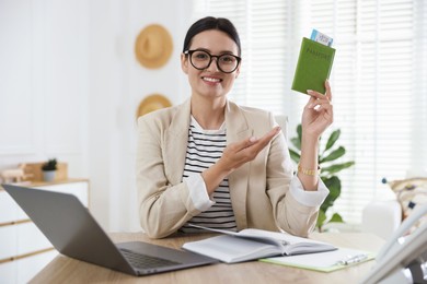 Photo of Travel agent with passport and ticket at wooden table in office