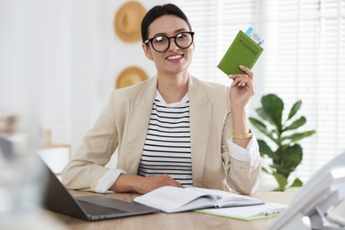Photo of Travel agent with passport and ticket at wooden table in office
