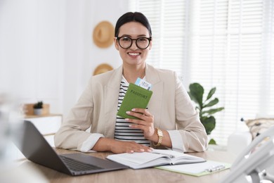 Photo of Travel agent with passport and ticket at wooden table in office