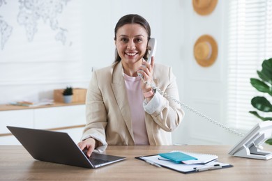 Photo of Travel agent working at wooden table in office