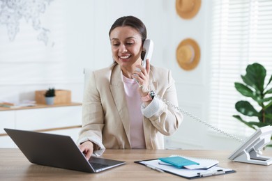 Photo of Travel agent working at wooden table in office
