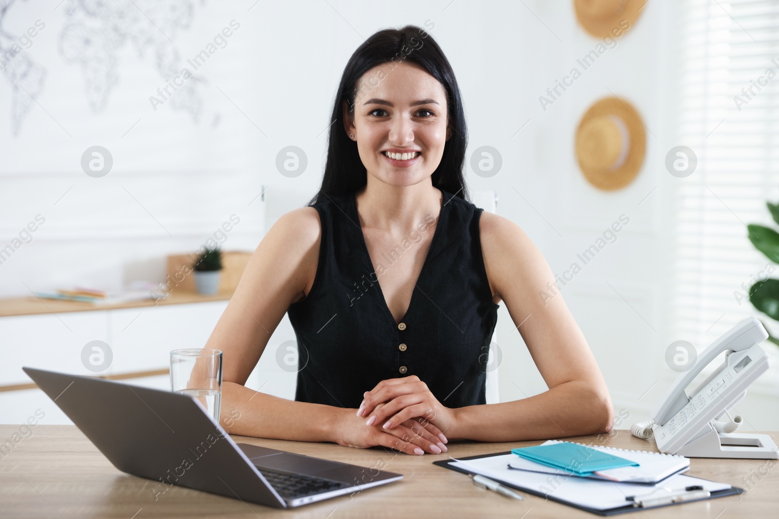 Travel agent working at wooden table in office Photo of Travel agent working at wooden table in office