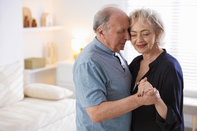 Photo of Lovely senior couple at home, space for text