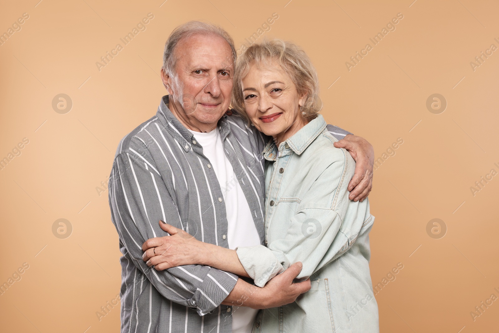 Portrait of lovely senior couple on beige background Photo of Portrait of lovely senior couple on beige background