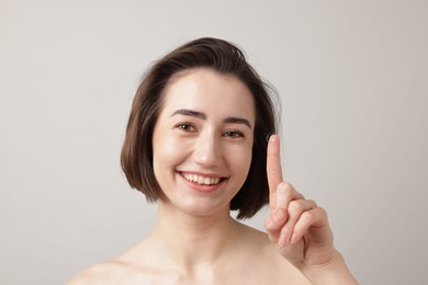 Photo of Woman with contact lens on light background