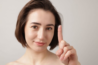 Photo of Woman with contact lens on light background