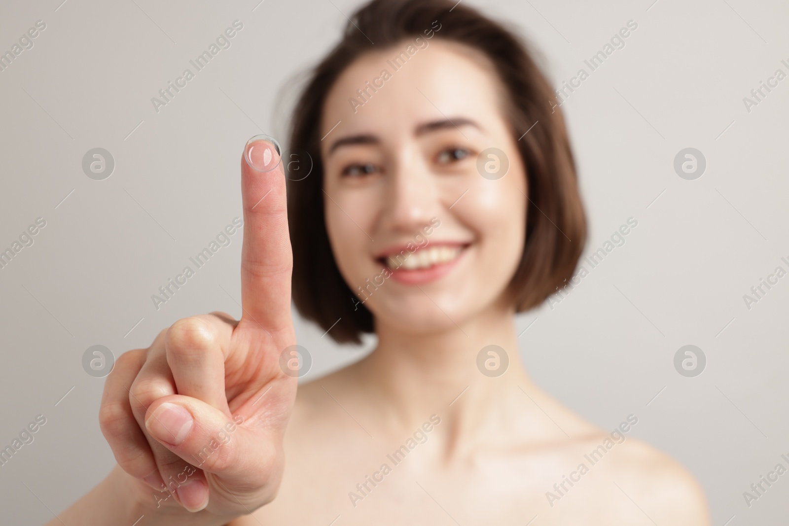 Woman with contact lens on light background, selective focus Photo of Woman with contact lens on light background, selective focus