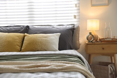Photo of Comfortable bed with soft linens and blankets in room, closeup. Home textile