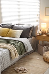 Photo of Comfortable bed with soft linens and blankets in room. Home textile