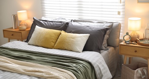 Photo of Comfortable bed with soft linens and blankets in room. Home textile