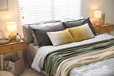 Photo of Comfortable bed with soft linens and blankets in room. Home textile