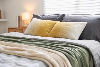 Photo of Comfortable bed with soft linens and blankets in room. Home textile