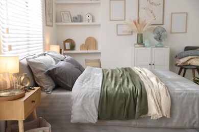Photo of Comfortable bed with soft linens and blankets in room. Home textile