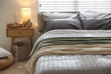 Photo of Comfortable bed with soft linens and blankets in room, closeup. Home textile